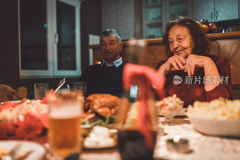 可爱的老年夫妇坐在餐桌上的家庭晚餐