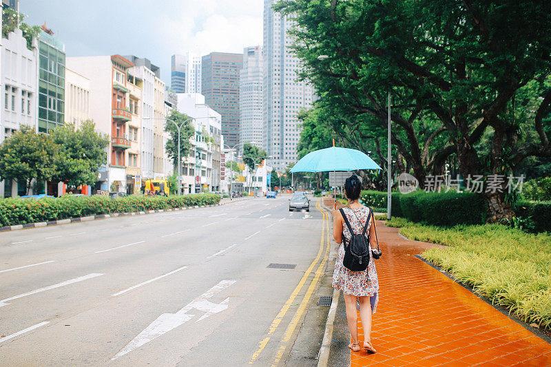 年轻时尚的单身旅行者在新加坡市中心散步