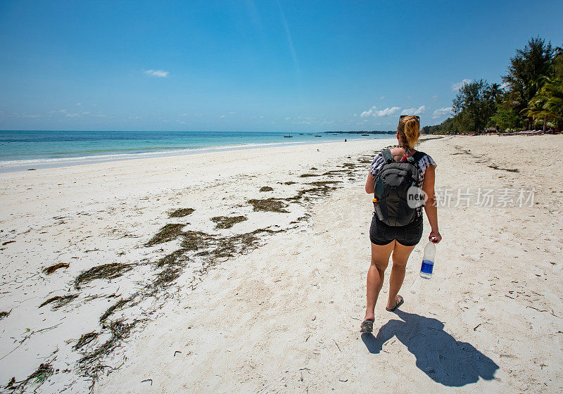 年轻女子探索一个热带岛屿的沙滩度假