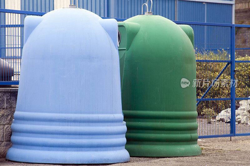 蓝色和绿色的大垃圾桶，用于回收利用。