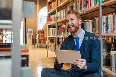 快乐的男人在家里用数码平板电脑