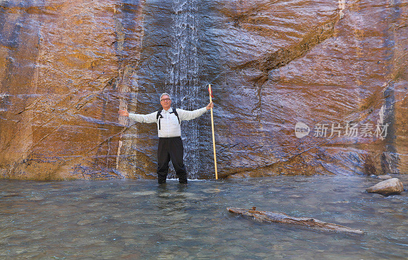 活跃的老年人在锡安国家公园的狭窄地带徒步旅行。神秘的瀑布。