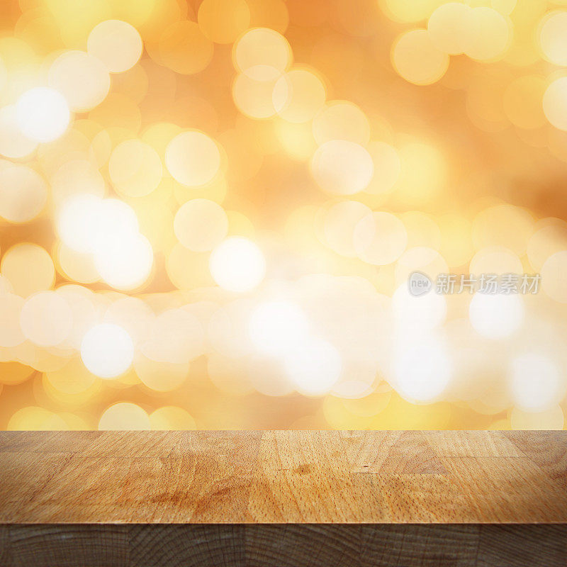 空木桌顶和模糊明亮的金色背景与灯光和散景，焦点放在桌面上