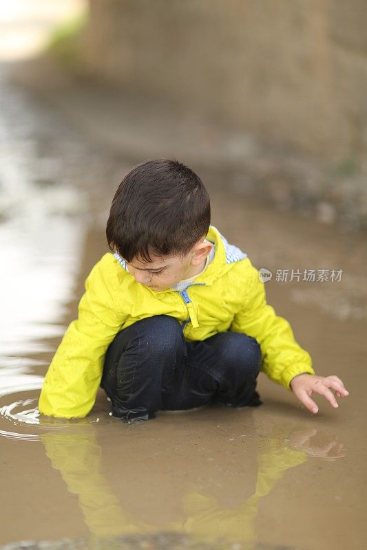 孩子们在雨坑里玩耍