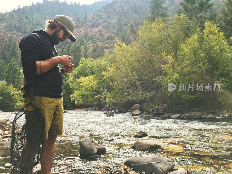 年轻的千禧一代男子在科罗拉多西部的圣米格尔河钓鱼