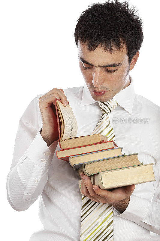 一个年轻英俊的白人男子的肖像穿正装孤立在白色背景在一个灰尘书，读一篇有趣的文章