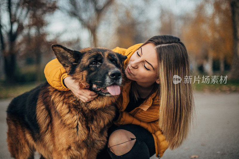 年轻女子和德国牧羊犬在公园里玩