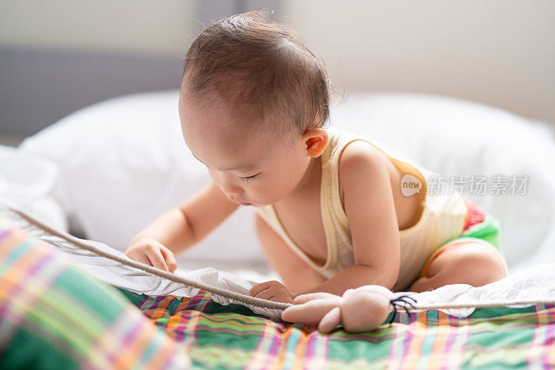 一个一岁的亚洲宝宝独自在卧室里探索