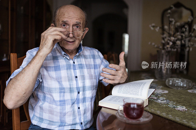 老人在家里喝茶看书