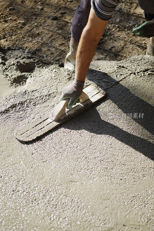 近距离的建筑工人平与泥铲混凝土