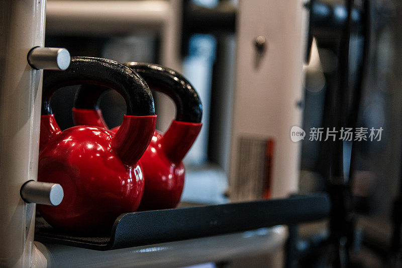 复制健身房里两个红色壶铃的照片