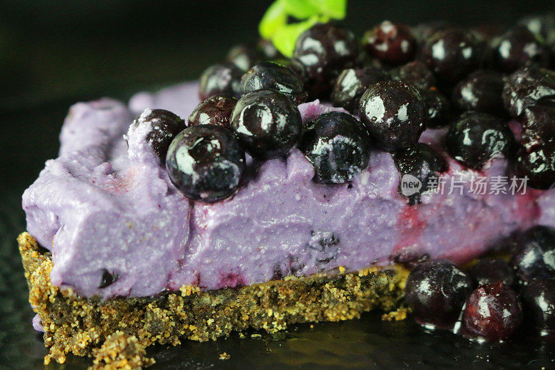 蓝莓芝士蛋糕，以黄油饼干为底色，蓝莓马斯卡彭奶油芝士甜点布丁，上面点缀新鲜蓝莓和薄荷叶