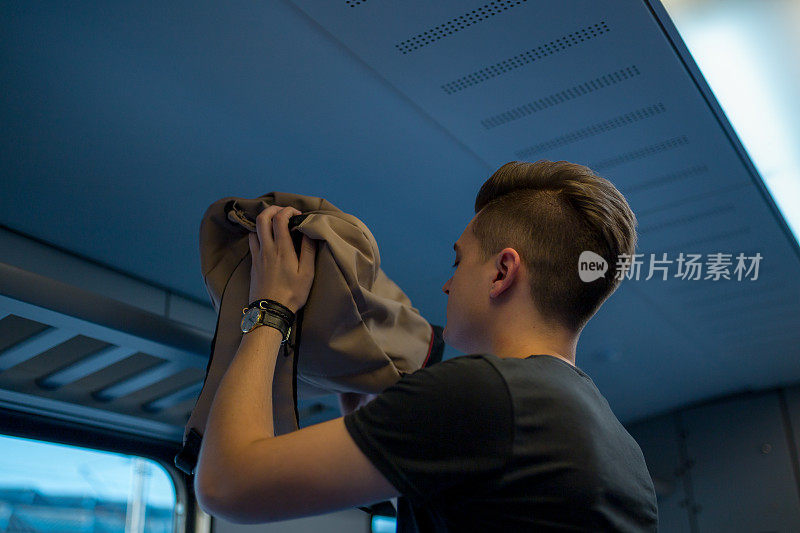 在阳光明媚的夏日里，年轻的成年男子独自乘坐火车旅行