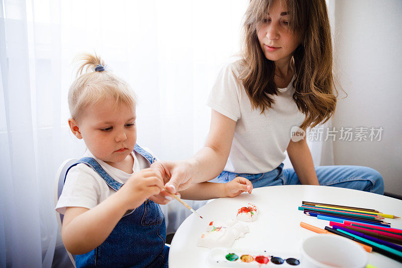 妈妈和女儿一起画画。那孩子和他母亲一起画画。