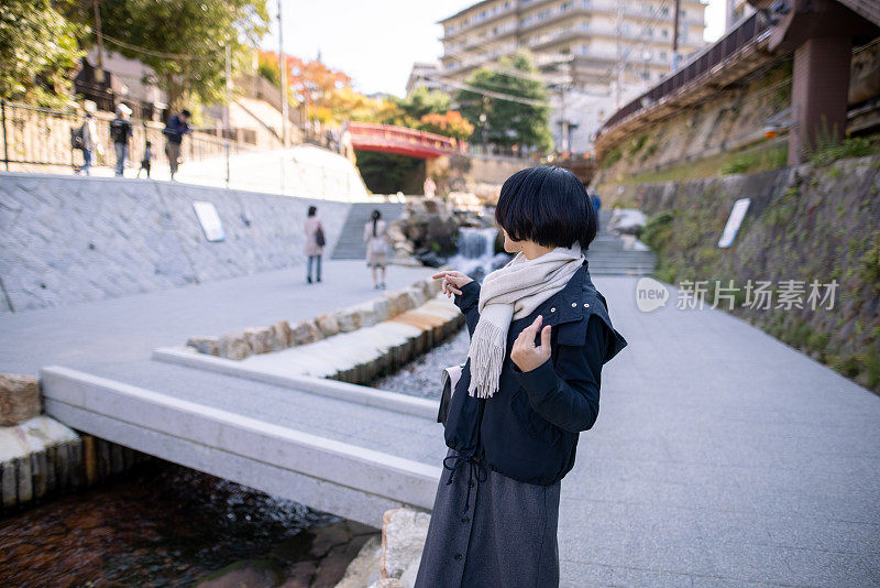 年轻女子沿着河在观光地点