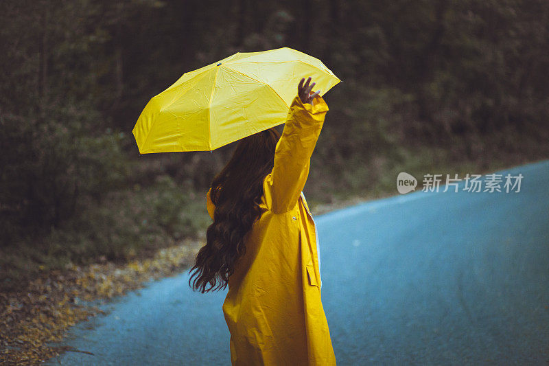 在秋天的彩色森林里撑着伞的女人