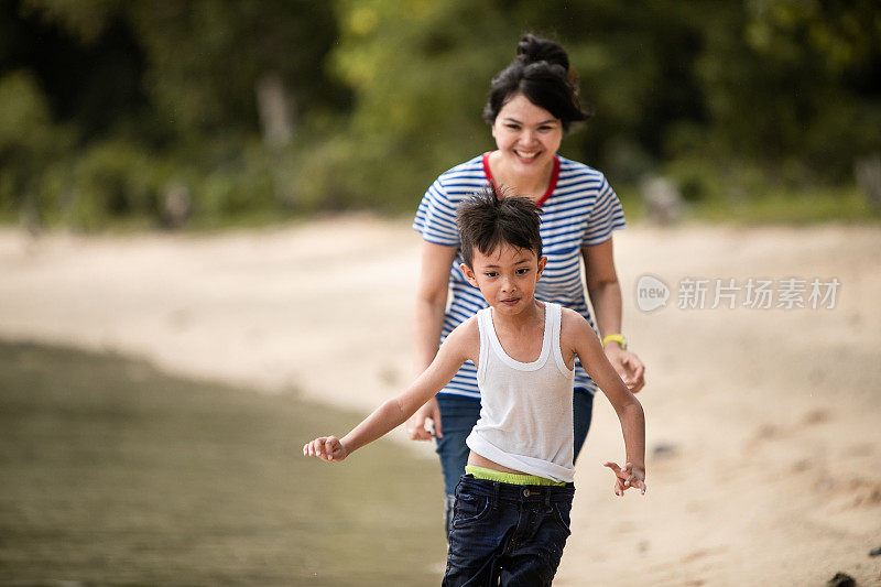 妈妈在海滩上追赶小男孩