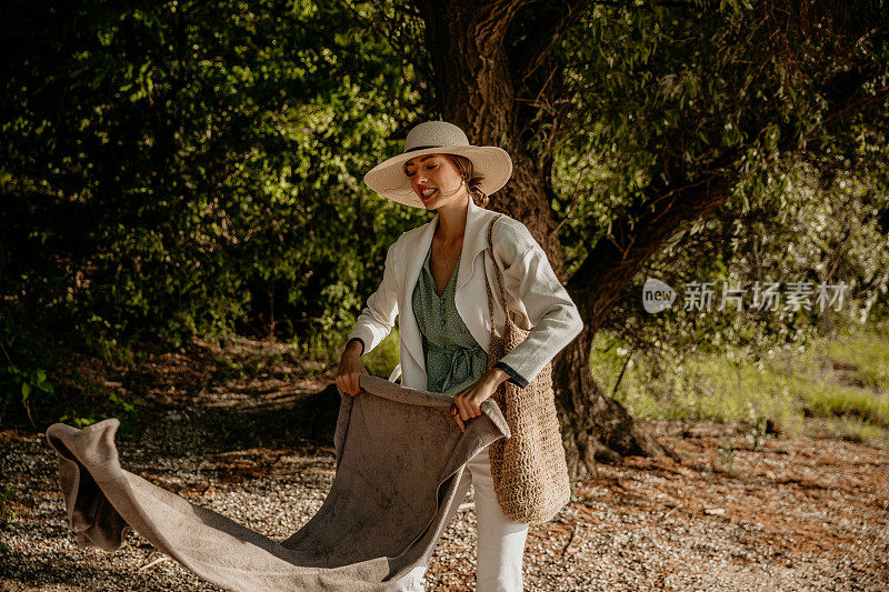 一名女性正在盖野餐毯