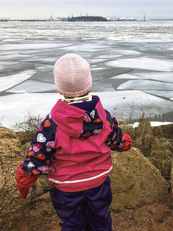 一个孩子看着海上漂浮的冰。春天，波罗的海的冰裂开了。
