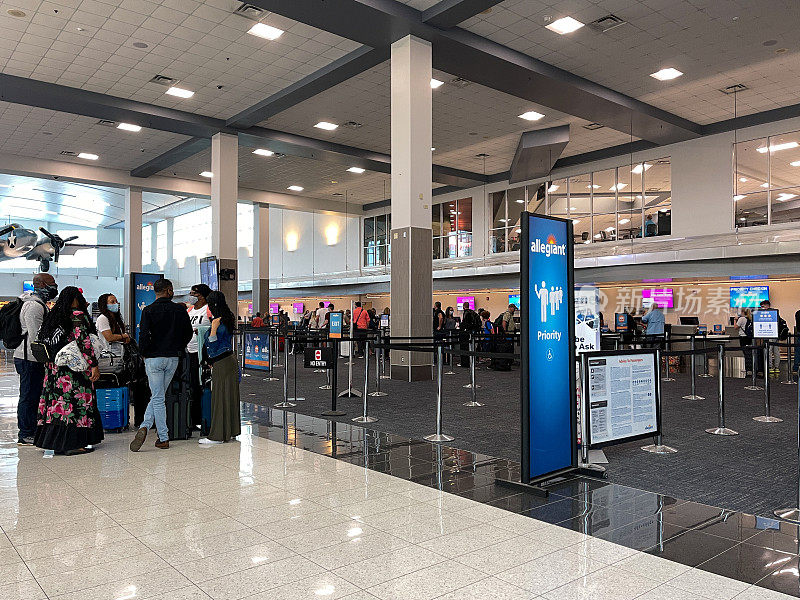 在繁忙的机场，人们在忠诚航空公司的值机柜台等待取票。