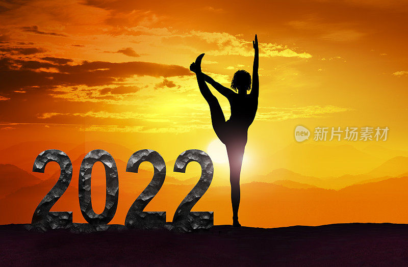 和日落时做瑜伽的女人祝2022年新年快乐