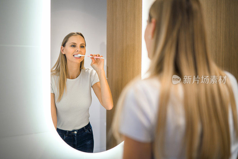年轻女子在镜子前刷牙