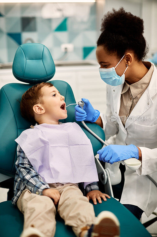 小男孩和黑人女口腔科医生在牙科诊所预约。