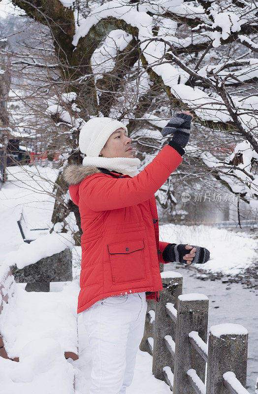 游客们在下雪的冬天享受他们的日本之旅。