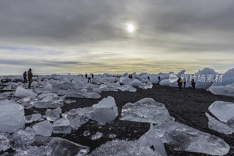 冰岛，退潮时，游客在冰山之间的钻石海滩上