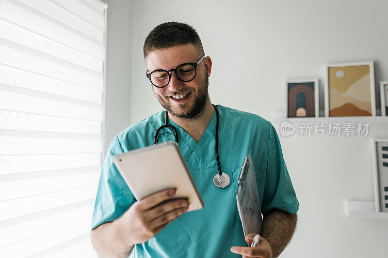 年轻的男医生在医院使用平板电脑