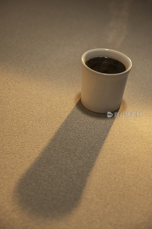 日出时分，餐厅里一杯孤零零的热气腾腾的咖啡