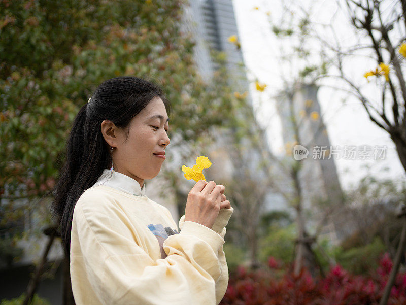 女人手里拿着黄色的花