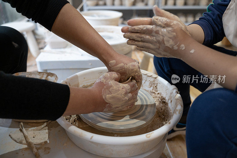 一个孩子正在手工作坊里制作陶器