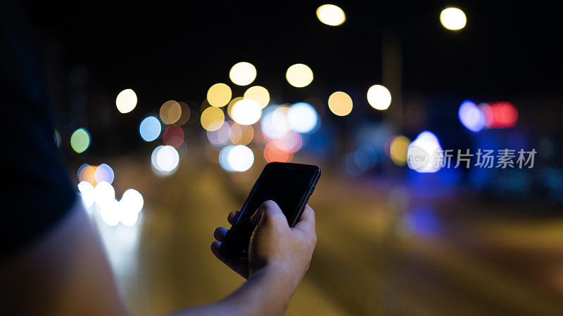 男人的手在晚上用智能手机