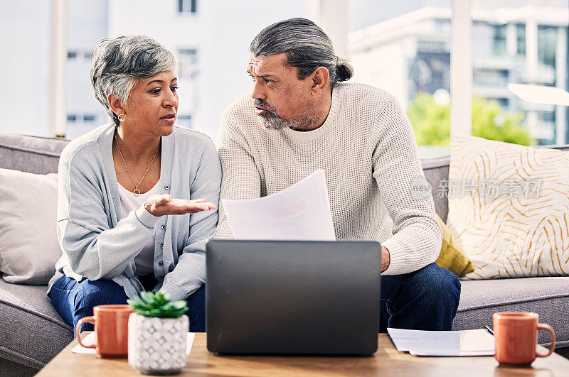 老年夫妇，文件和压力在笔记本电脑上与财务文书，税务或退休问题在家里。规划、负债和老人沙发上的人寿保险、账单或资产管理