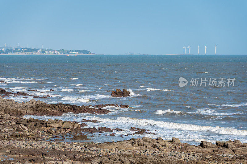 在晴朗的日子里，海边的礁石和海浪