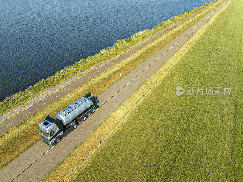 在乡间道路上行驶的带有拖车的载货液体的卡车