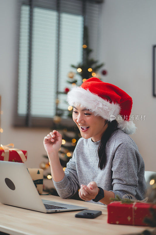 亚洲女性喜欢在圣诞节当天在家办公室用笔记本电脑进行视频会议。