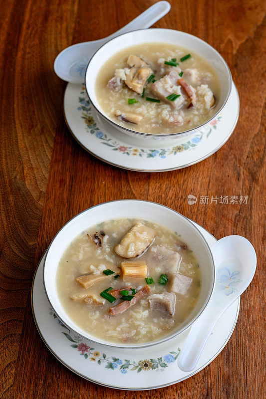 传统的中国食物——美味的海鲜和鸡汤粥，装在古董骨瓷碗里