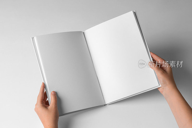 白色背景上的空书模板，手打开书与空白页。设计模型