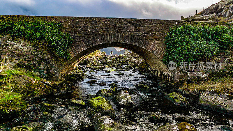 爱尔兰克里郡邓洛峡谷鸟瞰图，女人在古老的石桥下看自然，在自然中自由，在自然中坚强的女人，向自然致敬的女人，电影般的自然照片，放松冥想的自然
