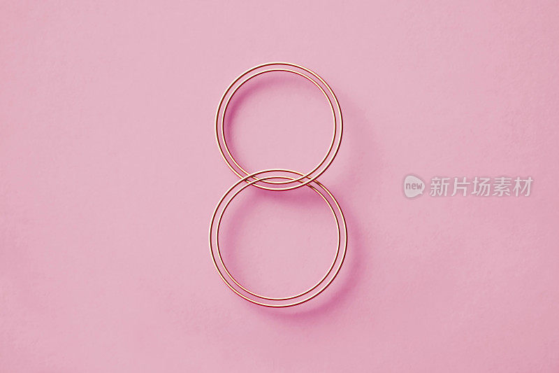 国际妇女节概念——粉色背景上的金色数字8