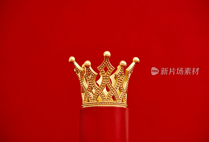 红色底座上装饰的金色皇冠。红色背景与复制空间