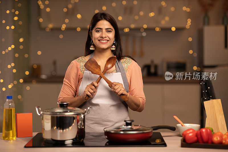 一个年轻女子的肖像烹饪食物在厨房的股票照片