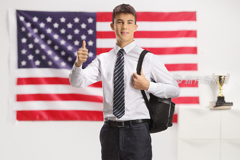 白人男学生在美国国旗前竖起大拇指