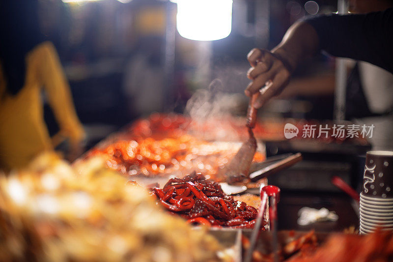 街头小吃摊贩手煮辣海鲜小吃的孤立镜头