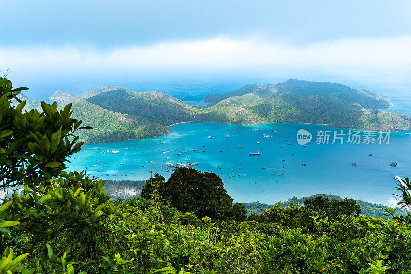 越南孔岛本丹港，湛蓝的大海，蓝天山和五颜六色的船只。