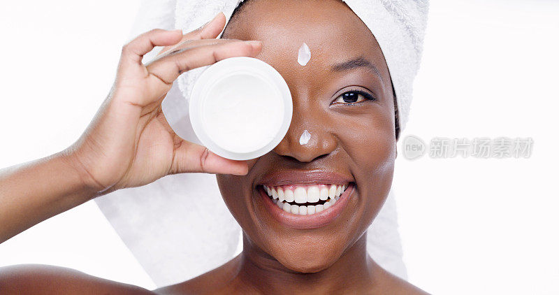 产品、护肤品和面霜，上面有黑人女性在摄影棚的肖像，用于美容、沐浴和保湿。化妆品，面部护理和水疗，化妆水在白底女模特的脸上，自我护理