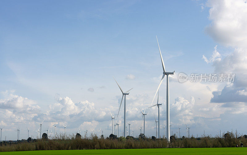 绿色田野里的风力发电机，绿色稻田里发电的风车群，农村绿色田野里的风力发电机，鸟瞰图