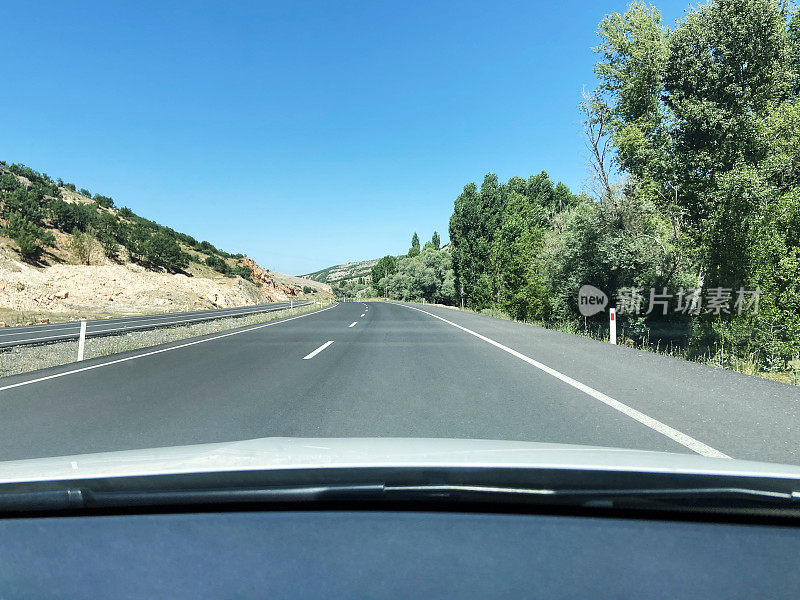 在阳光明媚的日子里在柏油路上开车